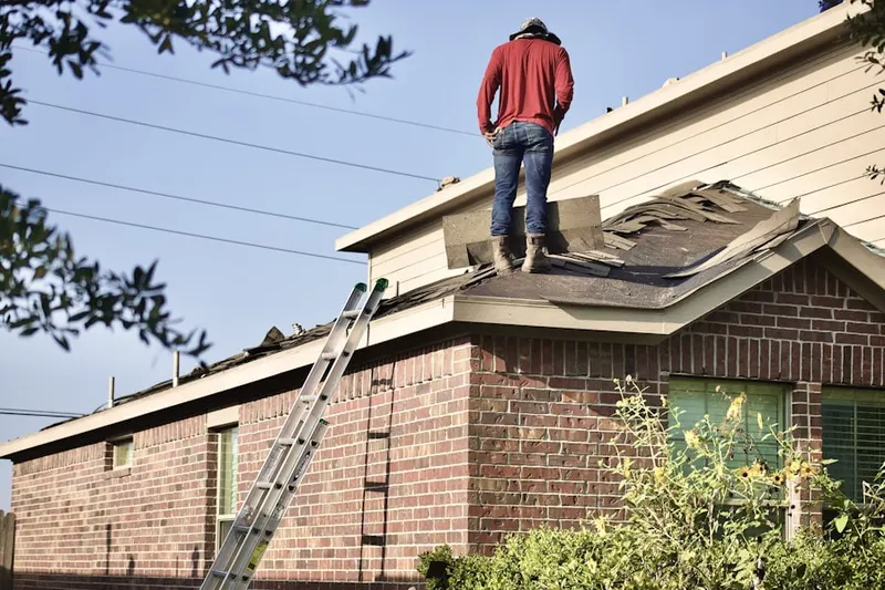 Professional roofer working on a residential roof in Belford Manor
